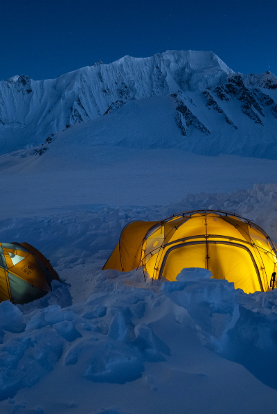Illuminated tents in the snow at night