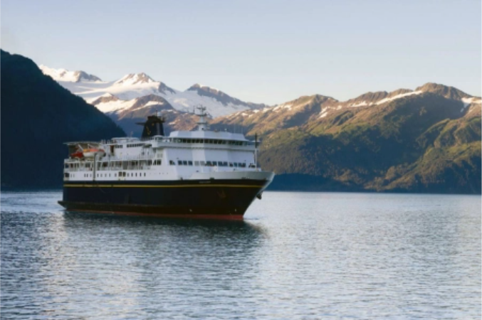 A ship in the water with snowy mountains in the background