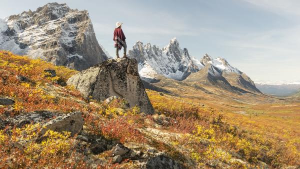 A person wearing a poncho looks out onto the Tombstone mountain range