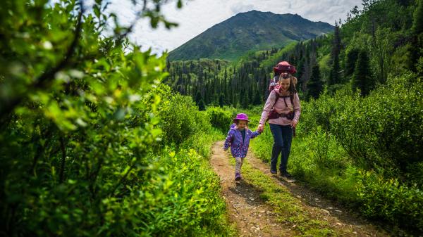 A family hiking on the St. Elias Trail in Kluane National Park and Reserve. The peak behind them is called Tl’eheda, which means “tent” in the Southern Tutchone language.