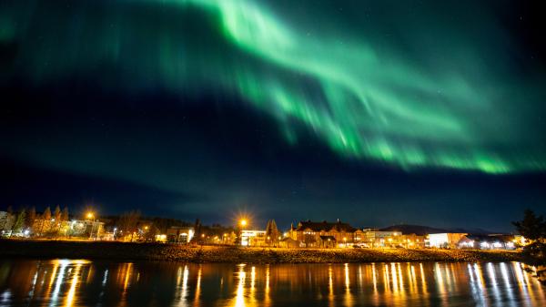 northern lights above whitehorse city lights