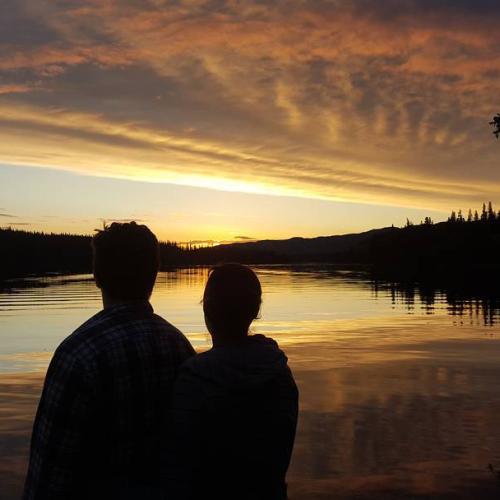 A couple enjoys a lakeside sunset