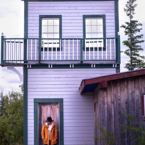 A woman standing in front of the purple Dawson City sign