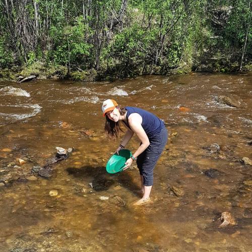 A woman pans for gold in a Yukon creek