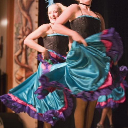 can can dancers in teal skirts dance on stage