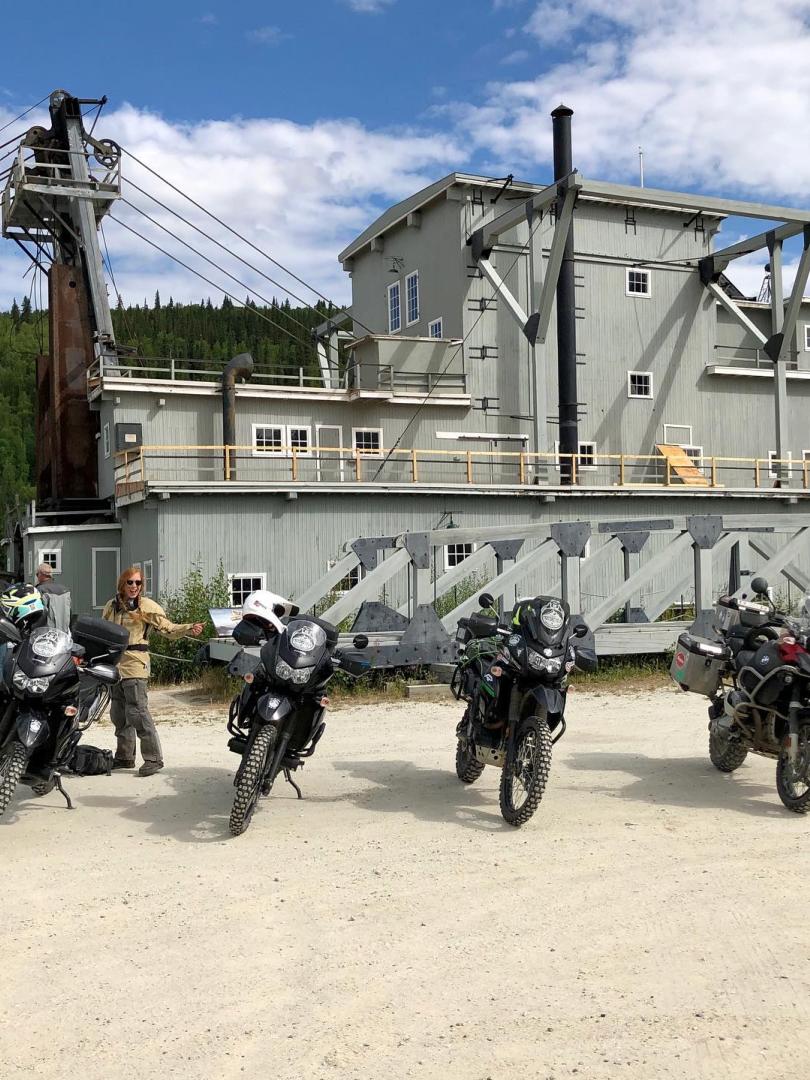 A group of motorcycles stand in front of Dredge No. 4 in Dawson City
