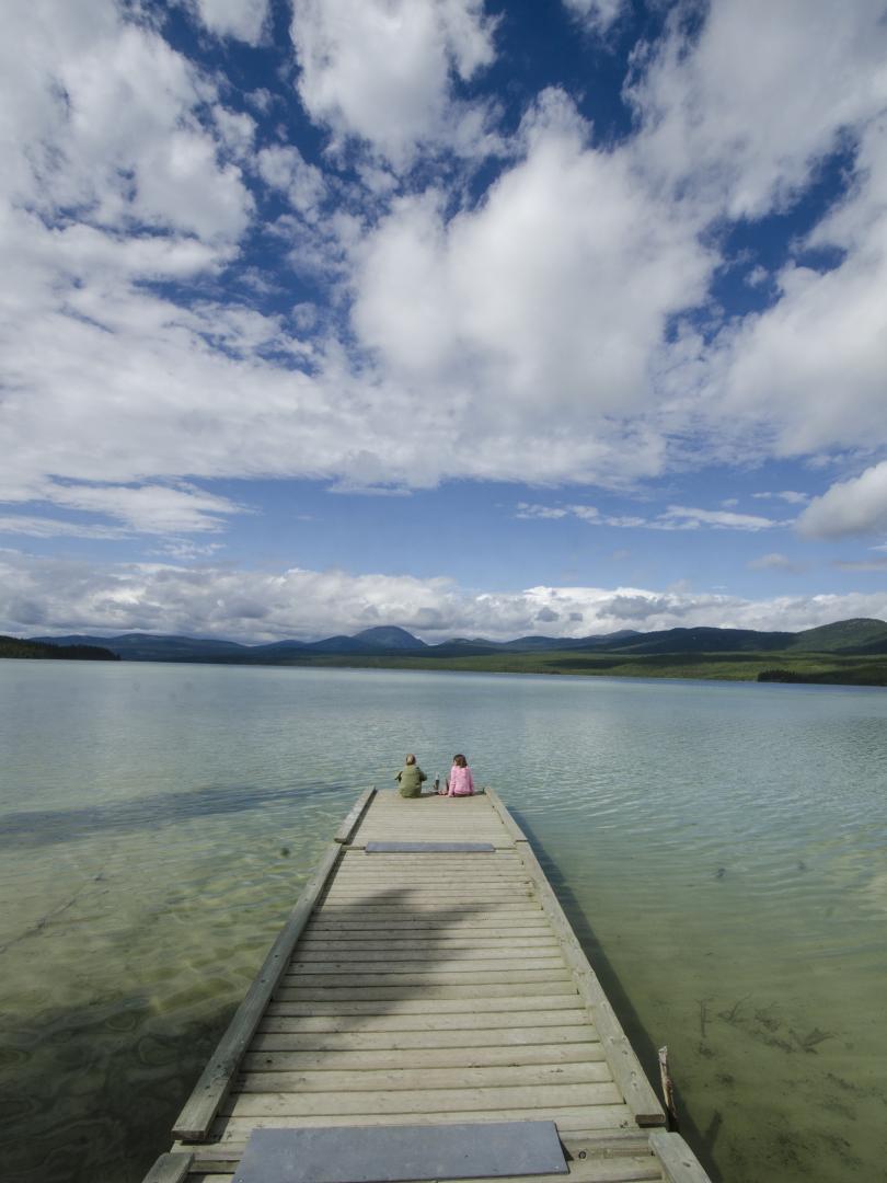 Two children sit on a dock at Squanga Lake Campground