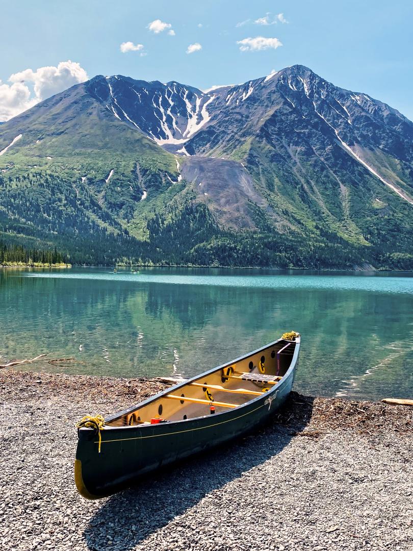A canoe sits on the short of Kathleen Lake