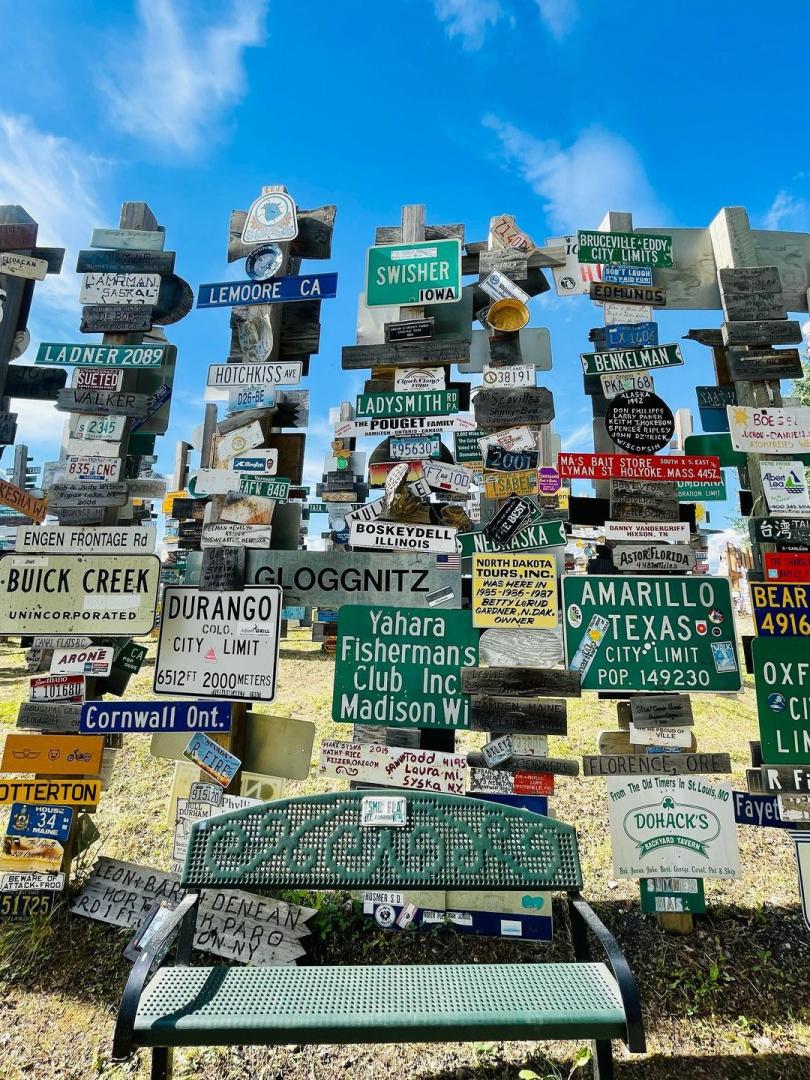 A bench sits in front of signs posts