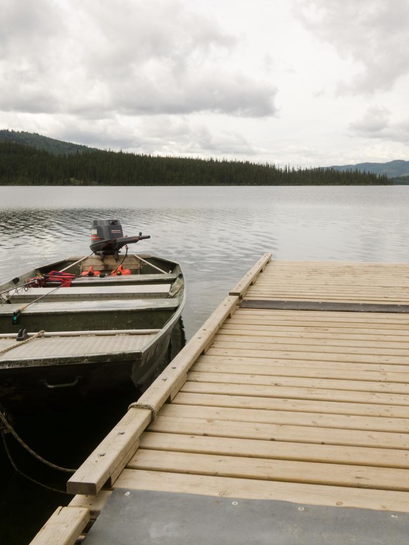 a dock and boat on the shore of a large lake