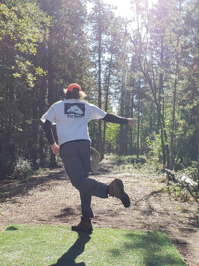 person throwing a disc while playing disc golf