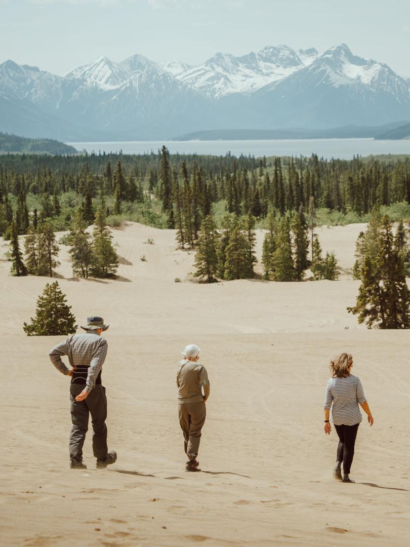 3 people wlking in the Carcross Desert