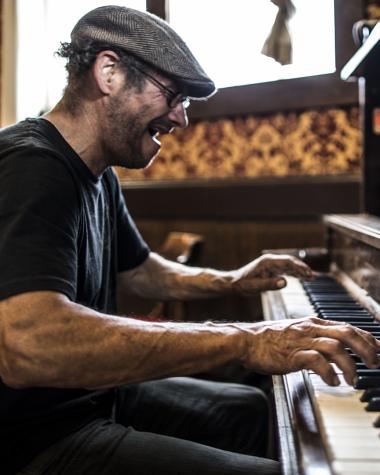 A man plays the piano in an old bar